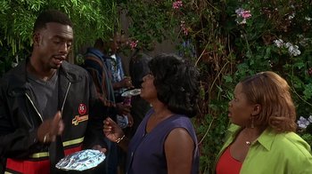 Movie still from “How to Be a Player” (1997), directed by Lionel C. Martin – A group of people standing next to each other near a bush; Medium shot, Over the shoulder angle