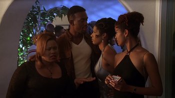 Movie still from “How to Be a Player” (1997), directed by Lionel C. Martin – A group of people standing next to each other at a party; Medium shot, Over the shoulder angle