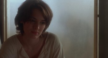 Movie still from “How to Make an American Quilt” (1995), directed by Jocelyn Moorhouse – A woman with short brown hair sitting in front of a window; Close Up shot, Over the shoulder angle