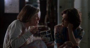 Movie still from “How to Make an American Quilt” (1995), directed by Jocelyn Moorhouse – Two women sitting on a couch eating ice cream; Medium shot, Over the shoulder angle