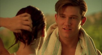 Movie still from “How to Make an American Quilt” (1995), directed by Jocelyn Moorhouse – A man with a towel around his neck is combing a woman's hair; Close Up shot, Over the shoulder angle