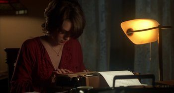 Movie still from “How to Make an American Quilt” (1995), directed by Jocelyn Moorhouse – A woman in a red dress looking at a book; Medium shot, Over the shoulder angle