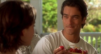 Movie still from “How to Make an American Quilt” (1995), directed by Jocelyn Moorhouse – A man and a woman sitting in front of each other holding tomatoes; Close Up shot, Over the shoulder angle