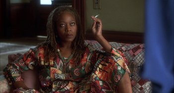 Movie still from “How to Make an American Quilt” (1995), directed by Jocelyn Moorhouse – A woman sitting on a couch smoking a cigarette; Close Up shot, High angle