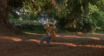 Movie still from “How to Make an American Quilt” (1995), directed by Jocelyn Moorhouse – A woman swinging on a swing in a park; Wide shot, High angle