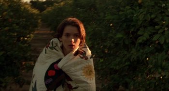 Movie still from “How to Make an American Quilt” (1995), directed by Jocelyn Moorhouse – A woman wrapped in a blanket in a forest; Close Up shot, High angle