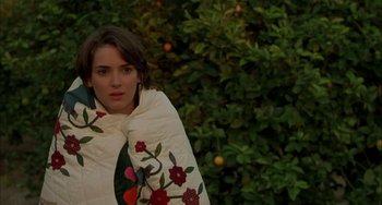 Movie still from “How to Make an American Quilt” (1995), directed by Jocelyn Moorhouse – A young woman wrapped in a blanket in front of a tree; Close Up shot, High angle