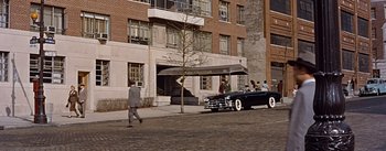Movie still from “How to Marry a Millionaire” (1953), directed by Jean Negulesco – A man walking down the street in front of a building; Extreme Wide shot, High angle