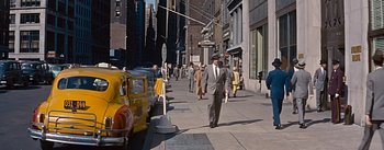 Movie still from “How to Marry a Millionaire” (1953), directed by Jean Negulesco – A man in a suit walking down a street; Wide shot, High angle