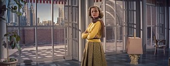 Movie still from “How to Marry a Millionaire” (1953), directed by Jean Negulesco – A woman standing in a room with her arms crossed; Medium shot, Low angle