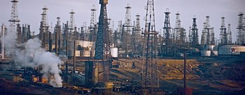 Movie still from “How to Marry a Millionaire” (1953), directed by Jean Negulesco – A group of oil derricks in the middle of a field; Extreme Wide shot, High angle