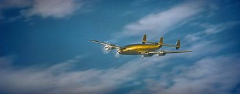 Movie still from “How to Marry a Millionaire” (1953), directed by Jean Negulesco – An airplane is flying through the air in the sky; Extreme Wide shot, Low angle