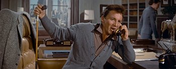 Movie still from “How to Marry a Millionaire” (1953), directed by Jean Negulesco – A man holding a cell phone up to his ear; Medium shot, Low angle