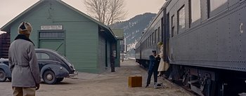 Movie still from “How to Marry a Millionaire” (1953), directed by Jean Negulesco – A man in a uniform standing next to a train car; Extreme Wide shot, Low angle
