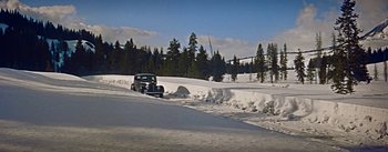Movie still from “How to Marry a Millionaire” (1953), directed by Jean Negulesco – An antique car driving down a snow covered road; Extreme Wide shot, High angle