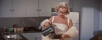 Movie still from “How to Marry a Millionaire” (1953), directed by Jean Negulesco – A woman pouring a cup of coffee into a coffee pot; Medium shot, Low angle