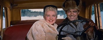 Movie still from “How to Marry a Millionaire” (1953), directed by Jean Negulesco – A man and a woman sitting in the back of a car; Medium shot, Low angle