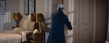 Movie still from “How to Marry a Millionaire” (1953), directed by Jean Negulesco – A man in a hat and a blue coat is opening a door; Medium shot, Low angle