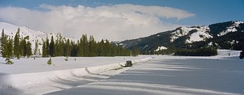Movie still from “How to Marry a Millionaire” (1953), directed by Jean Negulesco – A car driving down a snow covered road near a forest; Extreme Wide shot, High angle