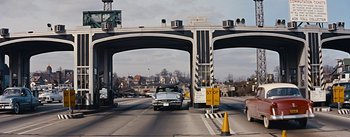 Movie still from “How to Marry a Millionaire” (1953), directed by Jean Negulesco – A car driving under an overpass on a highway; Extreme Wide shot, Over the shoulder angle