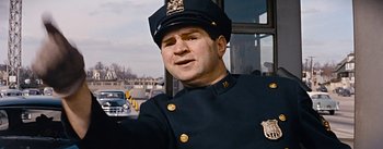 Movie still from “How to Marry a Millionaire” (1953), directed by Jean Negulesco – A man in a police officer's uniform; Medium shot, Low angle