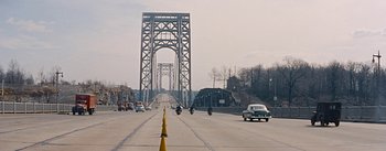Movie still from “How to Marry a Millionaire” (1953), directed by Jean Negulesco – Cars and motorbikes on a road near a large bridge; Extreme Wide shot, High angle