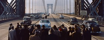 Movie still from “How to Marry a Millionaire” (1953), directed by Jean Negulesco – A group of people standing on the side of a bridge; Extreme Wide shot, High angle