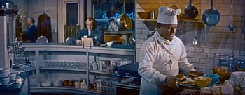 Movie still from “How to Marry a Millionaire” (1953), directed by Jean Negulesco – A man in a chef's outfit standing in front of a counter; Medium shot, Over the shoulder angle