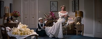 Movie still from “How to Marry a Millionaire” (1953), directed by Jean Negulesco – A woman sitting on a chair next to another woman; Medium shot, Over the shoulder angle