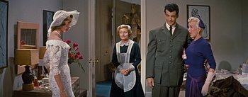 Movie still from “How to Marry a Millionaire” (1953), directed by Jean Negulesco – A man and a woman standing next to each other in a room; Medium shot, Low angle