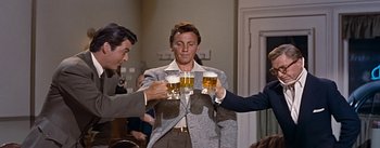 Movie still from “How to Marry a Millionaire” (1953), directed by Jean Negulesco – A group of people holding up glasses of beer; Medium shot, Low angle