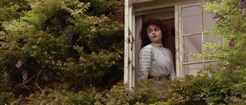 Movie still from “Howards End” (1992), directed by James Ivory – A woman standing at a window looking out of the window; Medium shot, Low angle