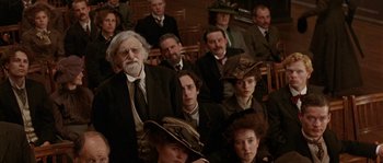 Movie still from “Howards End” (1992), directed by James Ivory – A group of people sitting and standing in a room; Medium shot, High angle