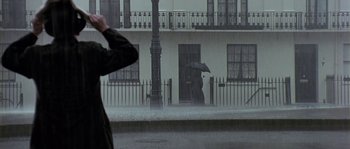 Movie still from “Howards End” (1992), directed by James Ivory – A person holding an umbrella while standing in the rain; Wide shot, Low angle