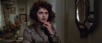 Movie still from “Howards End” (1992), directed by James Ivory – A woman with curly brown hair wearing a silver dress; Close Up shot, Over the shoulder angle