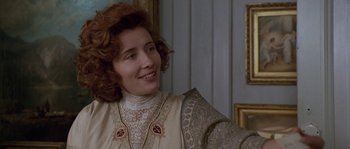 Movie still from “Howards End” (1992), directed by James Ivory – A person wearing a dress and smiling; Close Up shot, Over the shoulder angle