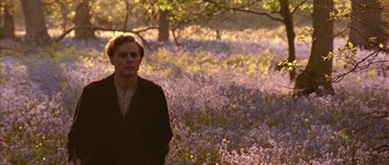 Movie still from “Howards End” (1992), directed by James Ivory – A man standing in a field of purple flowers; Medium shot, Low angle