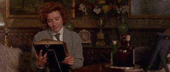Movie still from “Howards End” (1992), directed by James Ivory – A woman sitting at a table looking at a book; Close Up shot, Over the shoulder angle