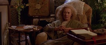 Movie still from “Howards End” (1992), directed by James Ivory – An older woman sitting in a chair in a living room; Medium shot, High angle