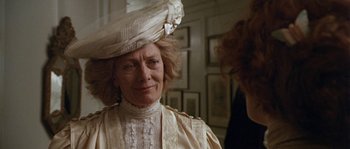 Movie still from “Howards End” (1992), directed by James Ivory – An older woman wearing a white dress and a white hat; Close Up shot, Over the shoulder angle