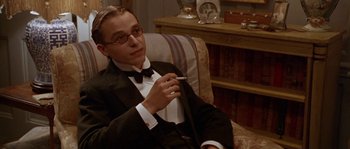 Movie still from “Howards End” (1992), directed by James Ivory – A man sitting in a chair holding a cigarette in his mouth; Close Up shot, Low angle