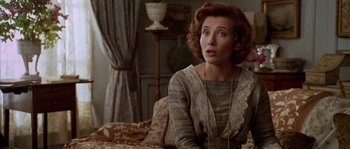 Movie still from “Howards End” (1992), directed by James Ivory – A woman in a dress sitting on a couch looking up; Close Up shot, Over the shoulder angle