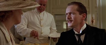 Movie still from “Howards End” (1992), directed by James Ivory – A man sitting at a table in front of another man; Close Up shot, Low angle