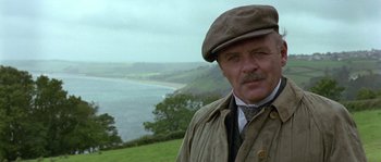 Movie still from “Howards End” (1992), directed by James Ivory – A person wearing a hat near a body of water; Close Up shot, Low angle
