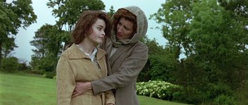 Movie still from “Howards End” (1992), directed by James Ivory – A woman in a hooded jacket holding a young girl in her arms; Medium shot, Over the shoulder angle