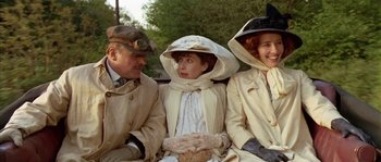Movie still from “Howards End” (1992), directed by James Ivory – A group of people sitting next to each other on a bench; Medium shot, Over the shoulder angle