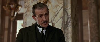 Movie still from “Howards End” (1992), directed by James Ivory – A person wearing a suit and tie; Close Up shot, Low angle