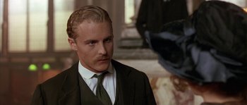 Movie still from “Howards End” (1992), directed by James Ivory – A person wearing a suit and a tie; Close Up shot, Over the shoulder angle