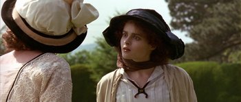 Movie still from “Howards End” (1992), directed by James Ivory – A young woman wearing a black hat and a white shirt; Close Up shot, Over the shoulder angle
