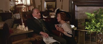 Movie still from “Howards End” (1992), directed by James Ivory – An older man sitting next to an older woman in a chair; Medium shot, Low angle